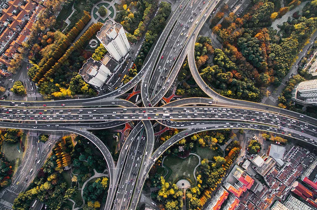 Image of infrastructure. Green surrounding highway from aerial view